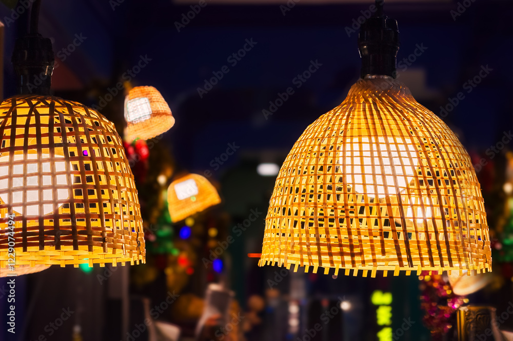Obraz premium Decorating hanging lantern lights lamp shade in handcraft wicker made from bamboo. Close-up lampshade in shape of basket from natural material in cafe interior. Cozy lightning decor of rattan celling.