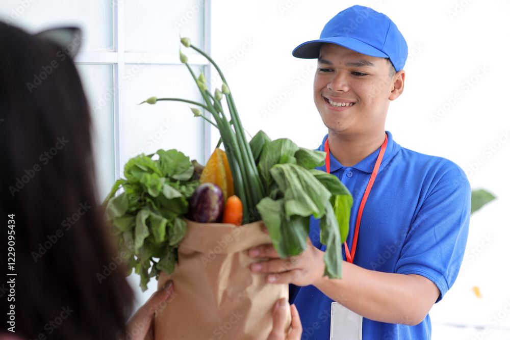 Asian Deliver Man Worker in Blue Uniform Handling Bag of Vegetable Give to Young Female Costumer in Front of the House Asian Deliver Man Worker in Blue Uniform Handling Bag of Vegetable Give to Young Female Costumer in Front of the House