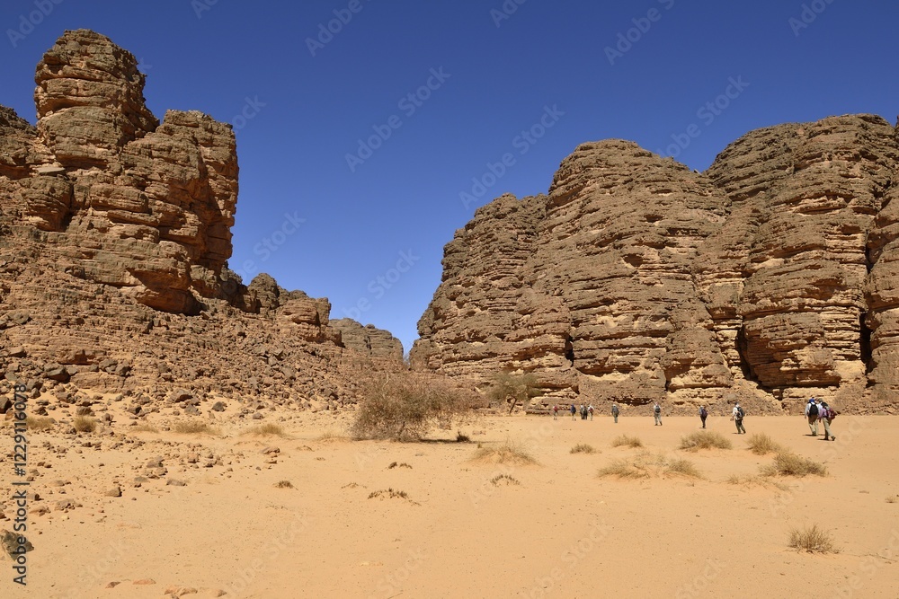 Hikers, group of people hiking in a canyon, Tassili n'Ajjer National Park, Sahara desert, Algeria, Africa Hikers, group of people hiking in a canyon, Tassili n'Ajjer National Park, Sahara desert, Algeria, Africa