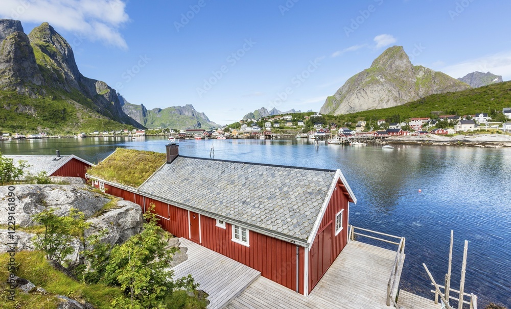Obraz premium Red house with a view over the fjord in summer, Reine or Rorbuer Rorbu fishing village, Reinefjord, Moskenesøy, Lofoten, Norway, Europe