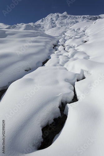 Snowy landscape with snow-covered stream, view of Zischgeles, Stubai Alps, Tyrol, Austria, Europe photo