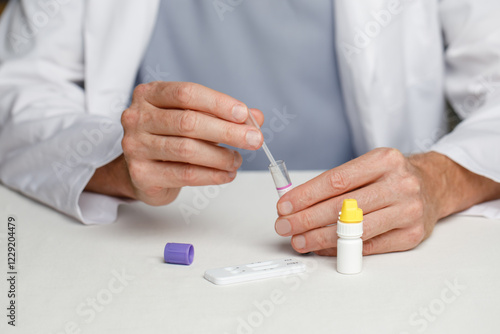 Male veterinarian practitioner doing medical sample rapid diagnostic test at examination room. Rapid test for detection of FIV and FeLV in cats photo