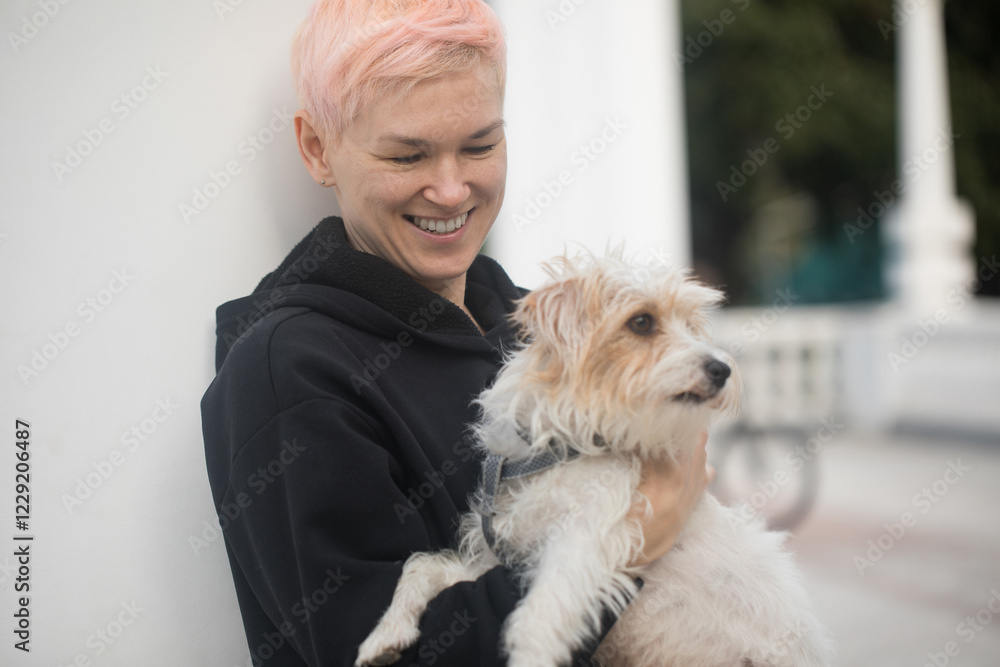 Friendly affectionate mature woman embracing pet dog Jack Russell Terrier in nature Friendly affectionate mature woman embracing pet dog Jack Russell Terrier in nature