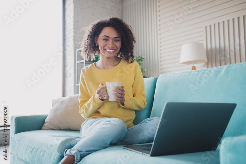 Young woman enjoying a relaxing moment at home with a cup of coffee and a laptop, seated on a comfortable couch Free Download Young woman enjoying a relaxing moment at home with a cup of coffee and a laptop, seated on a comfortable couch - GFXLoad