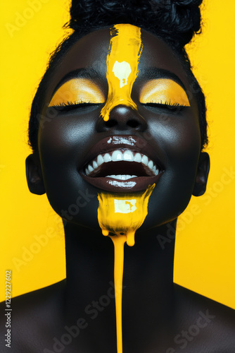 Cheerful young African woman with art fashion makeup. An amazing woman with black makeup and leaking yellow paint photo