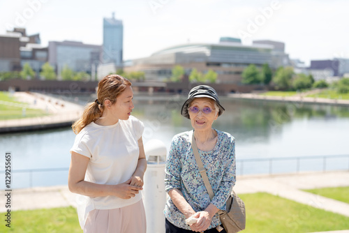 A park with good atmosphere with canal in Toyama Prefecture. Old woman in her 90s and Japanese woman in her thirties are walking around the park. photo