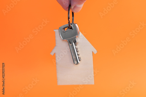 Hand holding a apartment keys on house shaped keyring photo