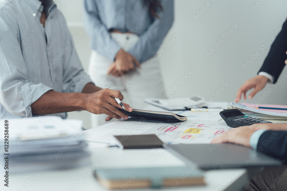 Strategic Collaboration: A close-up view of a team discussing ideas during a focused meeting, emphasizing the collaborative and analytical nature of modern work dynamics.