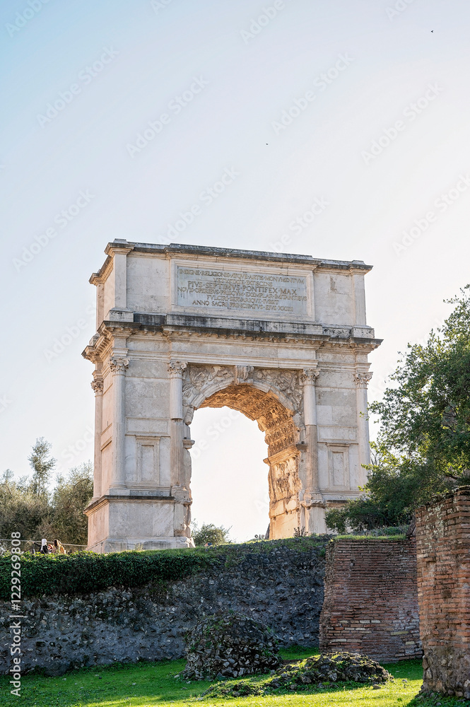 Ancient Roman triumphal arch surrounded by greenery in sunlight Ancient Roman triumphal arch surrounded by greenery in sunlight