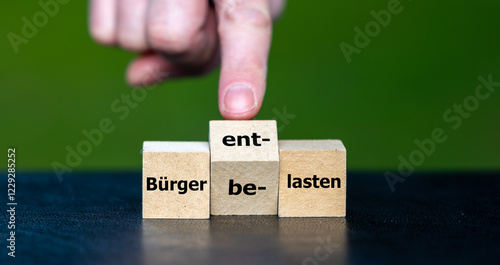 Hand turns the dice and changes the German expression (Buerger belasten) 'Burden citizens' to (Buerger entlasten) 'Relieve citizens'. photo