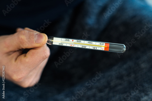 Obraz na płótnie Measuring body temperature with a classic thermometer, health and medicine.
w salonie