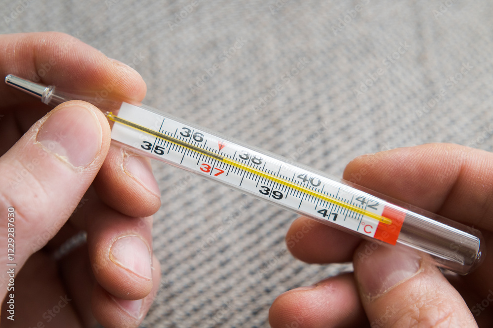 Measuring body temperature with a classic thermometer, health and medicine.