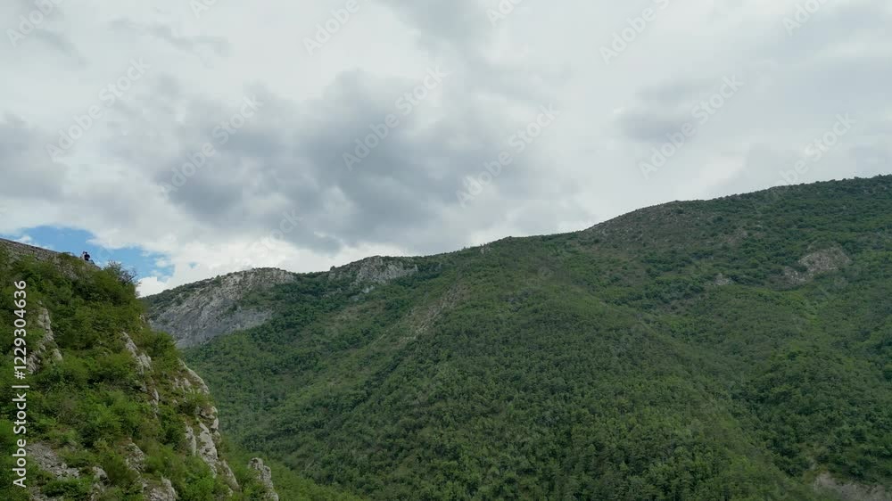 High-altitude view of a tranquil French mountain region, dotted with trees and wildflowers. High-altitude view of a tranquil French mountain region, dotted with trees and wildflowers.
