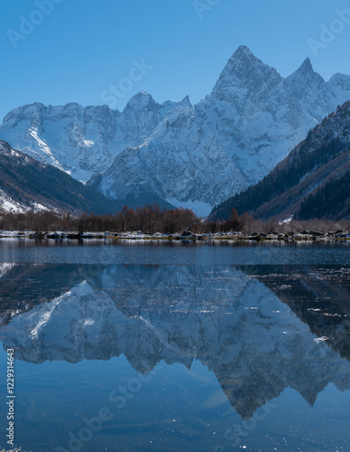 Teberda National Park. Snowy peaks of Mount Chotcha are reflected in lake as in mirror. Lake Tumanly-Gel or Tumanly-Kol (Misty Lake) is in valley of Gonachkhir River. Dombay, Karachay-Cherkessia. photo