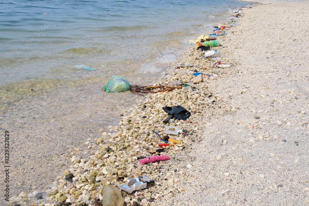Garbage trash rubbish waste being washed to the shoreline by sea waves.