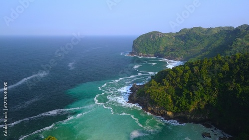 Drone view of coral hills on the edge of the sea with trees, coastal sand coral cliffs, and waves from the ocean at Sawangan Beach, Kebumen, Central Java photo