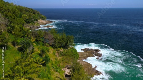 Drone view of coral hills on the edge of the sea with trees, coastal sand coral cliffs, and waves from the ocean at Sawangan Beach, Kebumen, Central Java photo