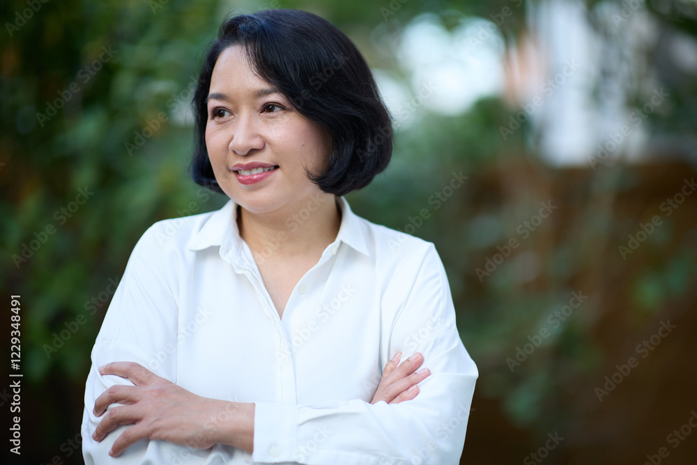 Portrait of smiling middle aged Asian business women in natural background Portrait of smiling middle aged Asian business women in natural background
