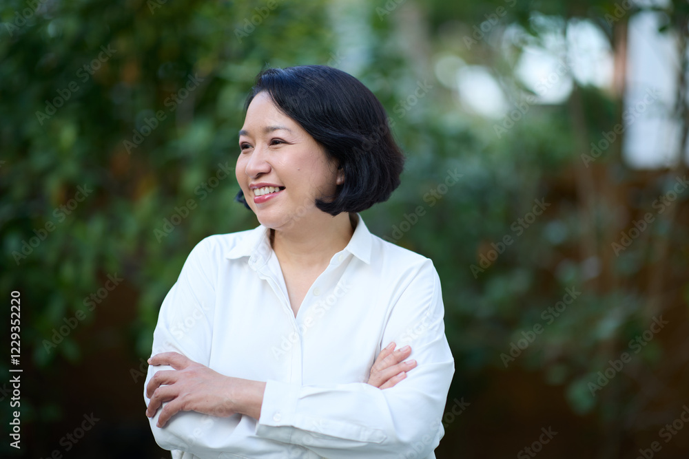 Portrait of smiling middle aged Asian business women in natural background Portrait of smiling middle aged Asian business women in natural background