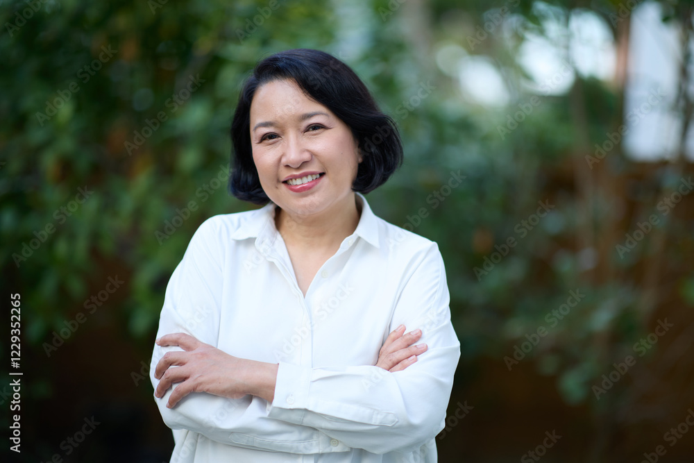 Portrait of smiling middle aged Asian business women in natural background Portrait of smiling middle aged Asian business women in natural background