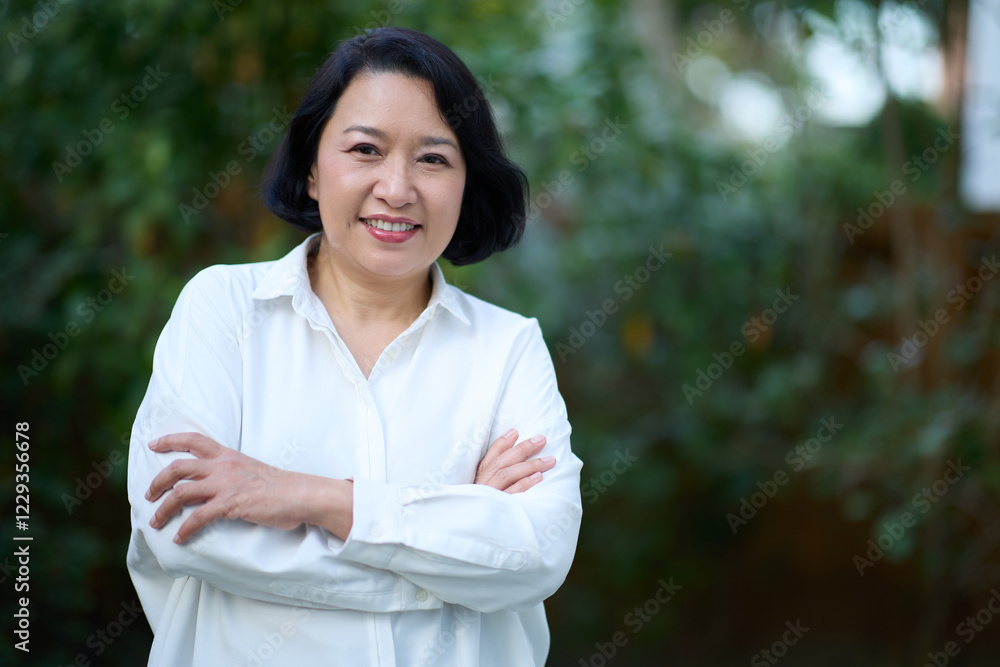 Portrait of smiling middle aged Asian business women in natural background Portrait of smiling middle aged Asian business women in natural background