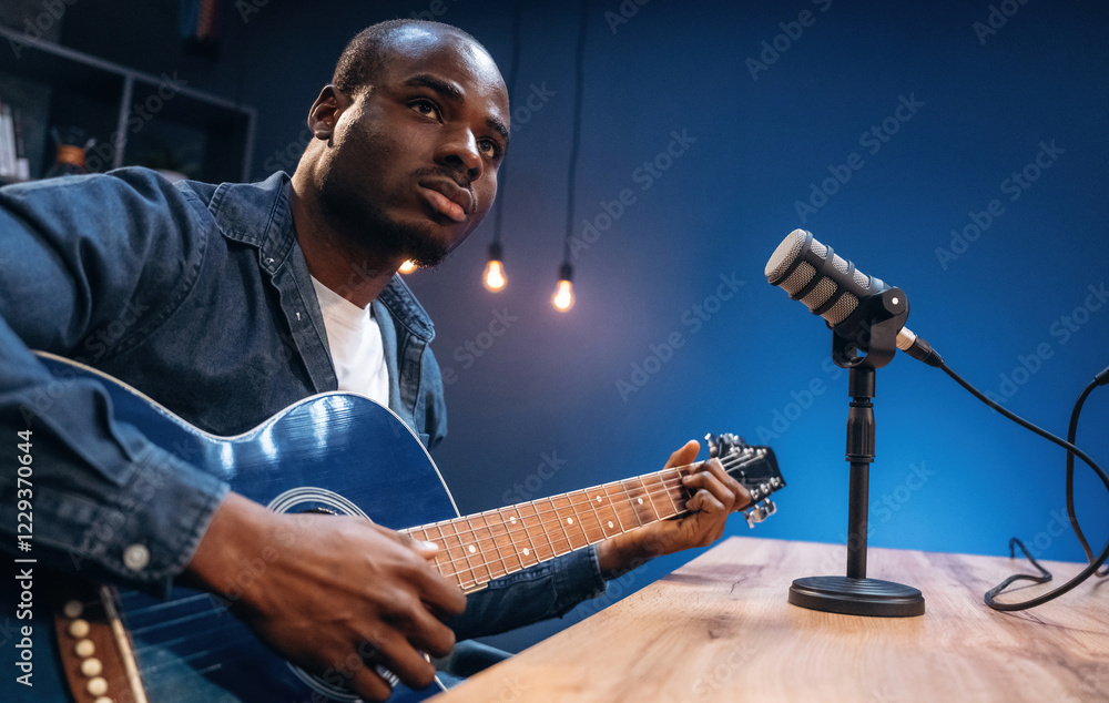 Obraz premium Singer songwriter with guitar. Man is doing podcast in the studio