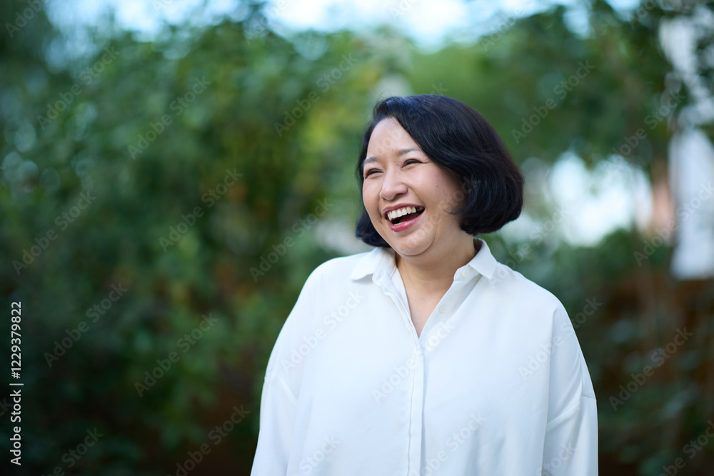 Portrait of smiling middle aged Asian business women in natural background Portrait of smiling middle aged Asian business women in natural background