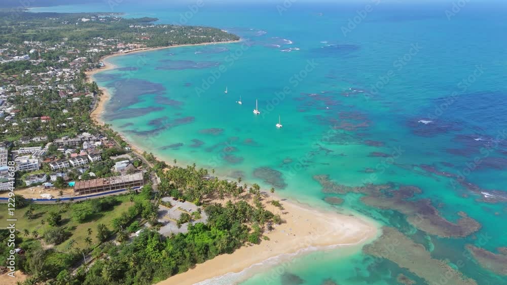 Aerial establishing shot of Punta Popy Beach in Las terrenas, Samana, Dominican Republic. Coral reef water and coastline of Dominican Republic. Sailing boat on water. Wide shot. Aerial establishing shot of Punta Popy Beach in Las terrenas, Samana, Dominican Republic. Coral reef water and coastline of Dominican Republic. Sailing boat on water. Wide shot.