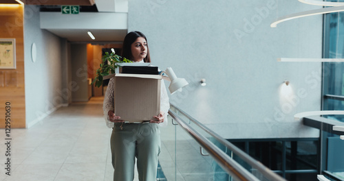 Sad, corporate and woman walk with box for work dismissal, fired and retrenched of unemployment. Unhappy, female person and items for resignation, termination eviction and recession notice of jobless photo