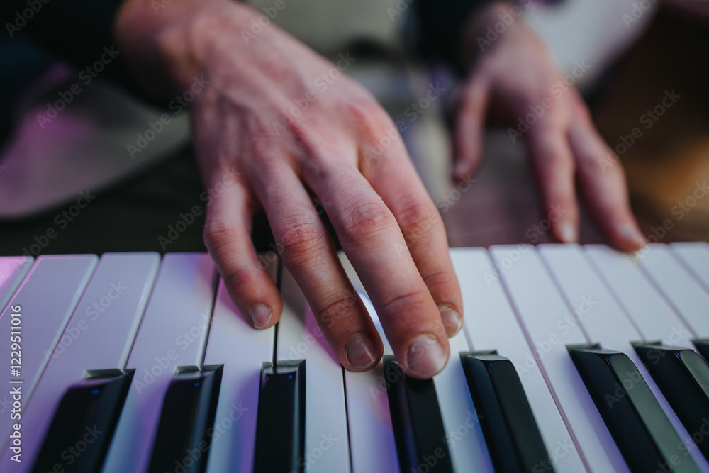 Fototapeta premium A detailed view of a musician's fingers playing a piano, showcasing the intricate relationship between touch and sound. The soft lighting enhances the focus on the musician's skilful hands.