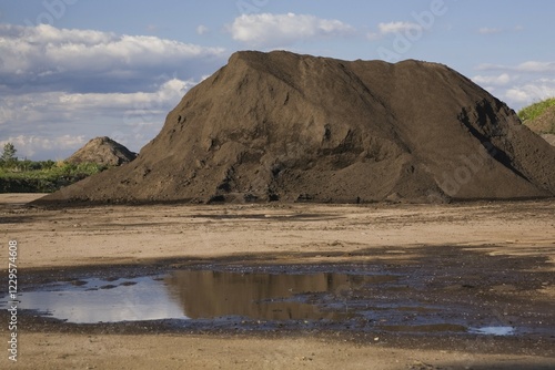 Mound of topsoil in a commercial sandpit after a heavy rainfall, Quebec, Canada, North America
