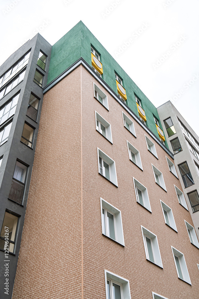 custom made wallpaper toronto digitalContemporary building with brick facade, green rooftop, yellow accents, against bright sky. Urban architecture concept low angle view