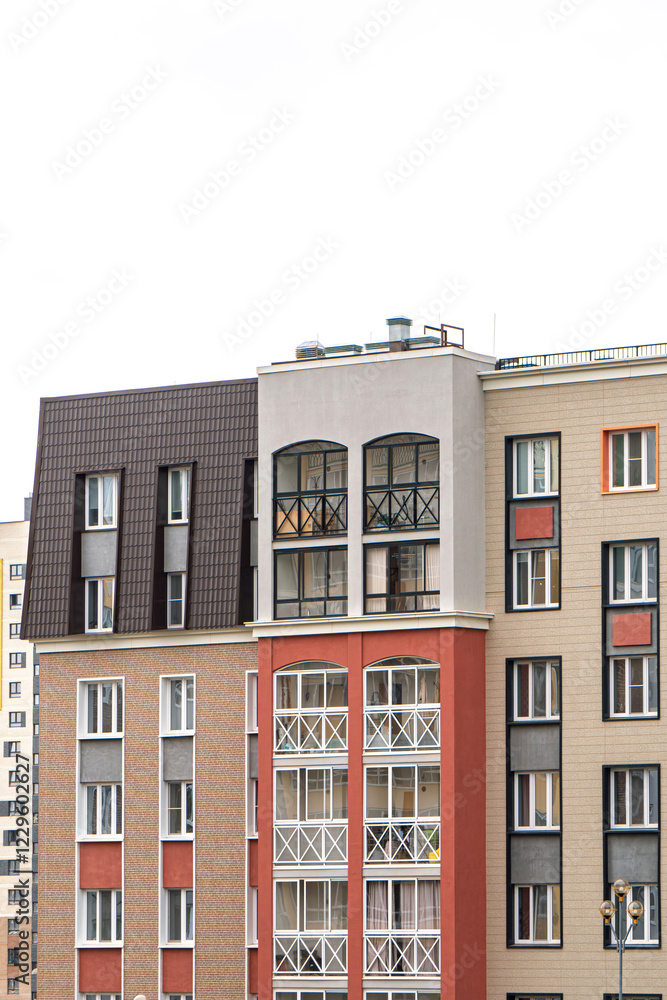 Contemporary apartment building with varied facade styles and balconies, featuring neutral and bold colours, under bright sky Contemporary apartment building with varied facade styles and balconies, featuring neutral and bold colours, under bright sky