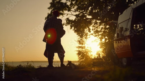Romantic weekend in nature, young married couple dancing against sunset sky. People traveling by caravan in national park, love and tenderness, motorhome trip across country, amazing natural landscape