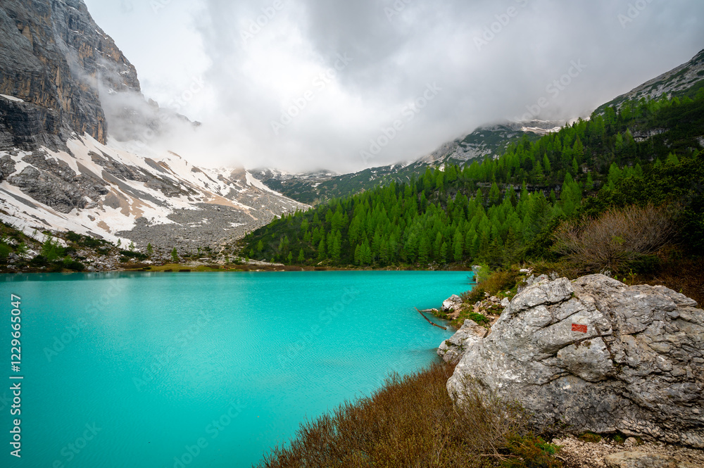 Panoramic view of Lago Sorapis in the Dolomites (Dolomiti, Dolomiten), Italy. The turquoise lake is surrounded by towering cliffs and mountains, a popular spot for hikers and nature lovers