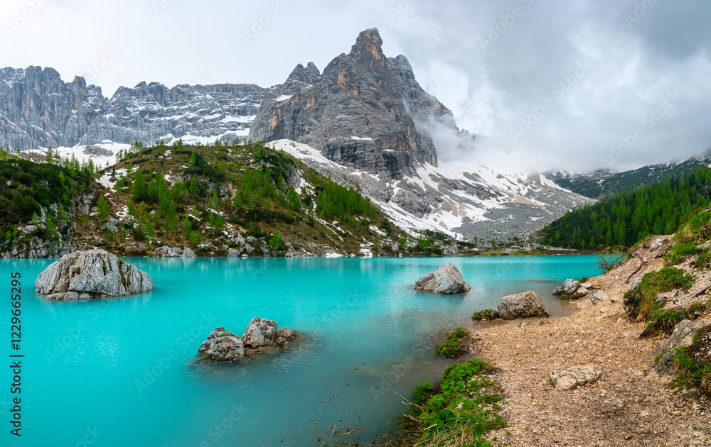 Panoramic view of Lago Sorapis in the Dolomites (Dolomiti, Dolomiten), Italy. The turquoise lake is surrounded by towering cliffs and mountains, a popular spot for hikers and nature lovers