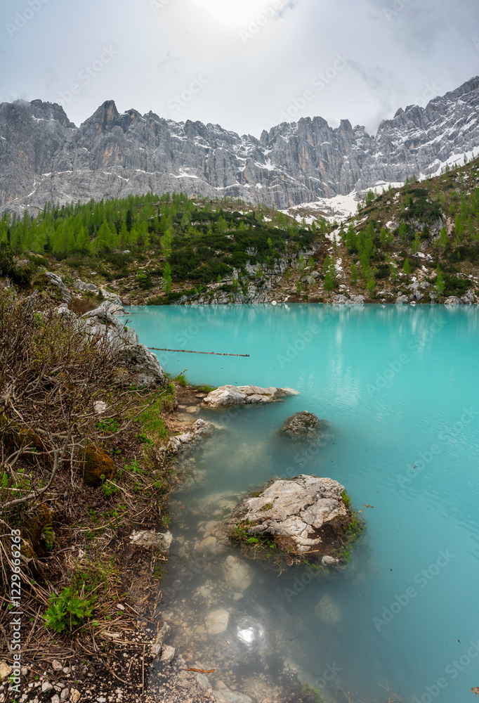 Panoramic view of Lago Sorapis in the Dolomites (Dolomiti, Dolomiten), Italy. The turquoise lake is surrounded by towering cliffs and mountains, a popular spot for hikers and nature lovers