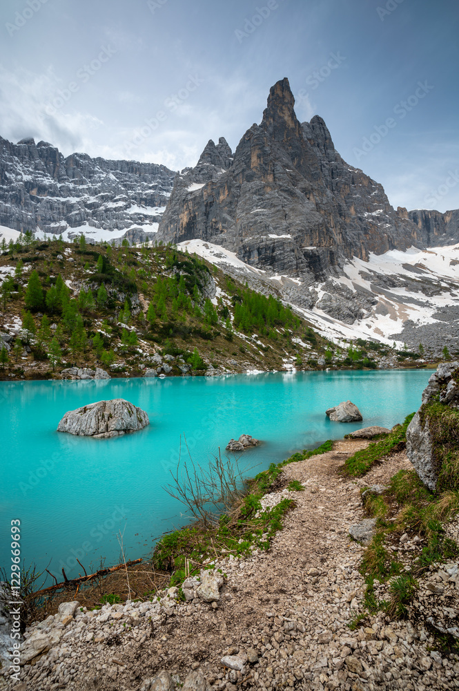 Panoramic view of Lago Sorapis in the Dolomites (Dolomiti, Dolomiten), Italy. The turquoise lake is surrounded by towering cliffs and mountains, a popular spot for hikers and nature lovers