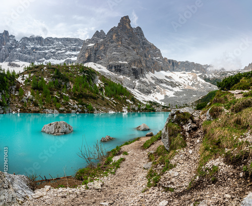 Panoramic view of Lago Sorapis in the Dolomites (Dolomiti, Dolomiten), Italy. The turquoise lake is surrounded by towering cliffs and mountains, a popular spot for hikers and nature lovers
