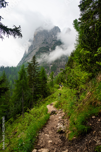 Obraz na płótnie Mountain trail in the Dolomites (Dolomiti, Dolomiten), Italy, leading to Lago Sorapis. The path winds along rocky slopes with stunning views of valleys, forests, and peaks w salonie