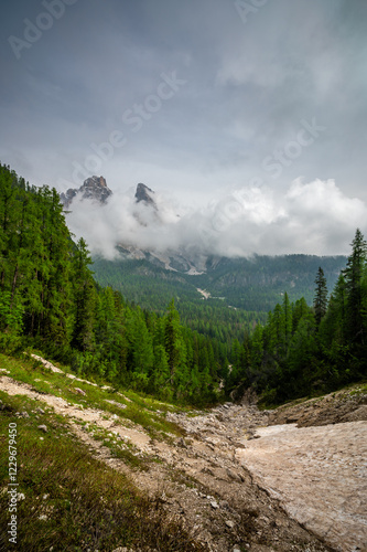 Obraz na płótnie Mountain trail in the Dolomites (Dolomiti, Dolomiten), Italy, leading to Lago Sorapis. The path winds along rocky slopes with stunning views of valleys, forests, and peaks w salonie