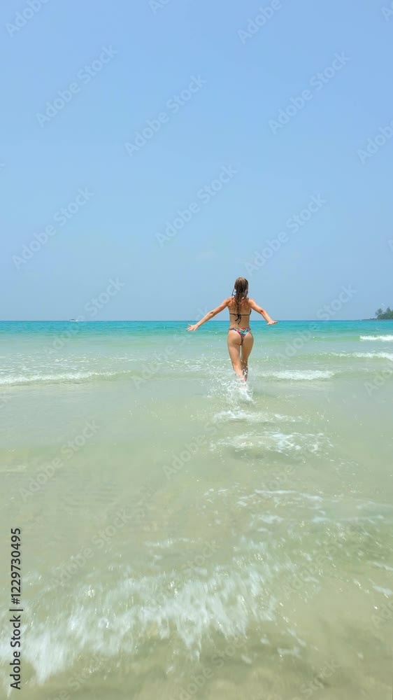 Happy Caucasian woman runs and jumps into the turquoise sea on paradise beach. Concepts of freedom, tropical vacation, and travel Happy Caucasian woman runs and jumps into the turquoise sea on paradise beach. Concepts of freedom, tropical vacation, and travel