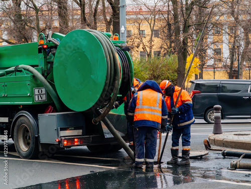 Sewer workers cleaning manhole and unblocking sewers photo