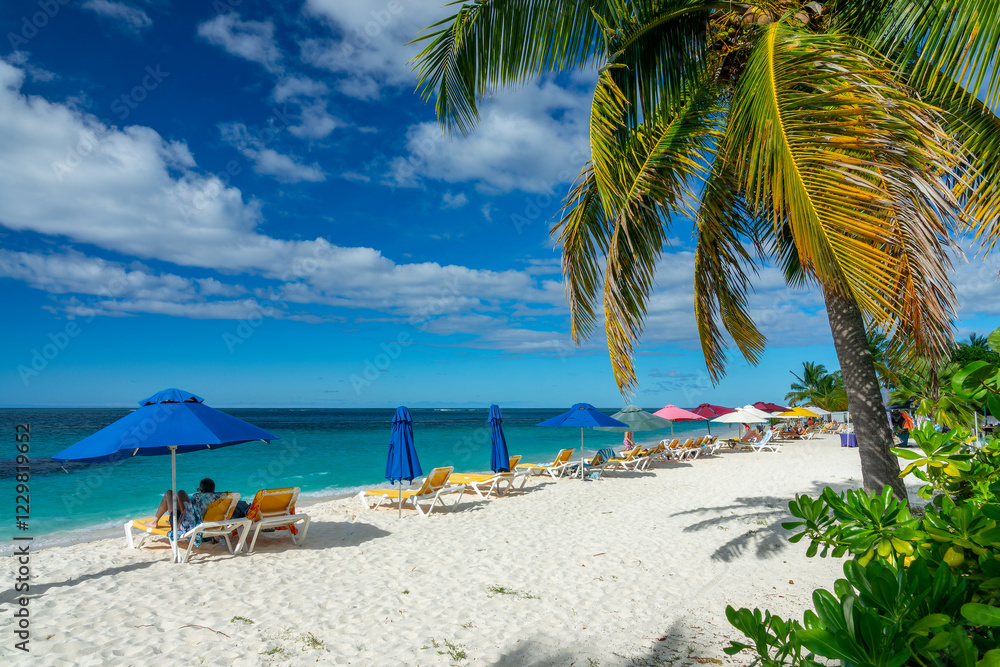 People and parasols in Shoal Bay beach, Caribbean dream landscape in Anguilla island, British West Indies People and parasols in Shoal Bay beach, Caribbean dream landscape in Anguilla island, British West Indies