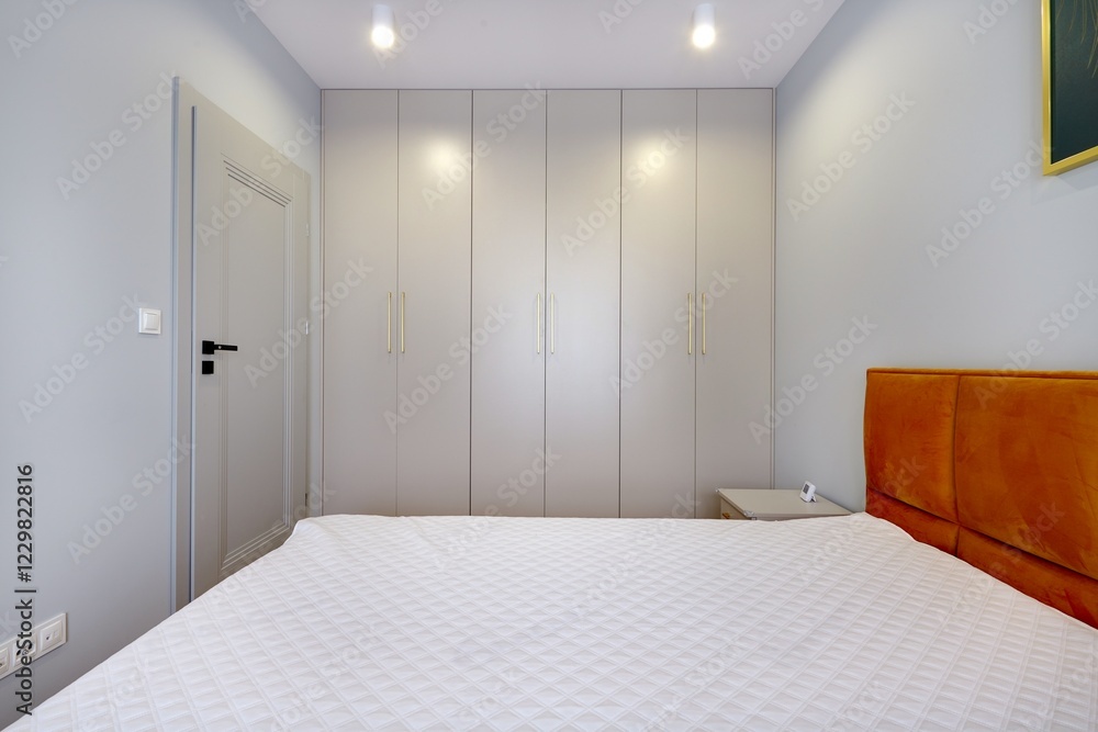 Sypialnia w nowoczesnym apartamencie z dużym materacem i białą szafą Sypialnia w nowoczesnym apartamencie z dużym materacem i białą szafą