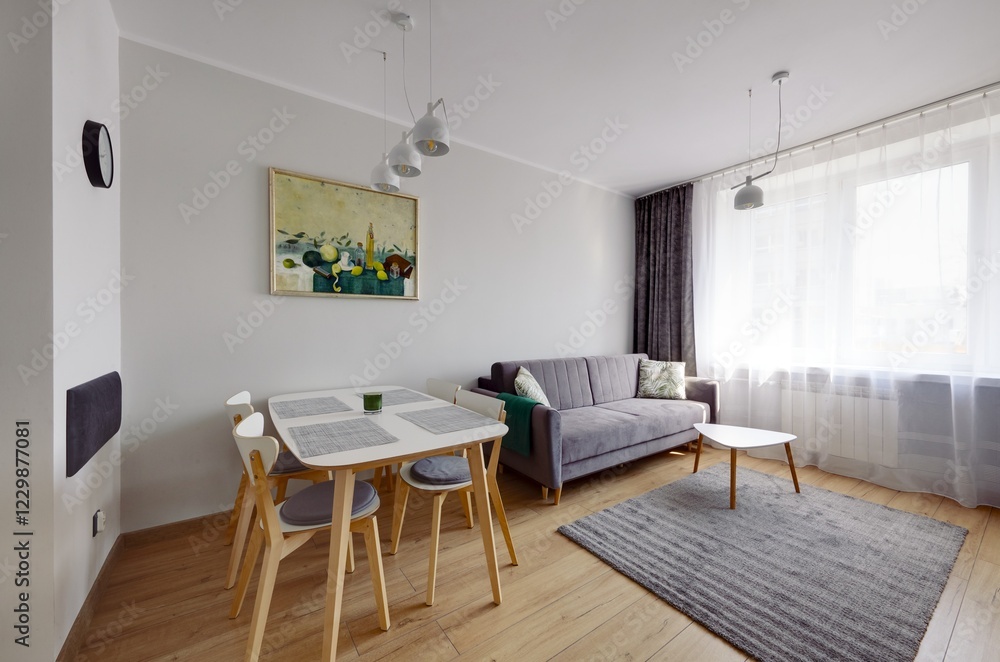 Fototapeta premium Salon w nowoczesnym apartamencie z beżową sofą, białym stołem z krzesłami