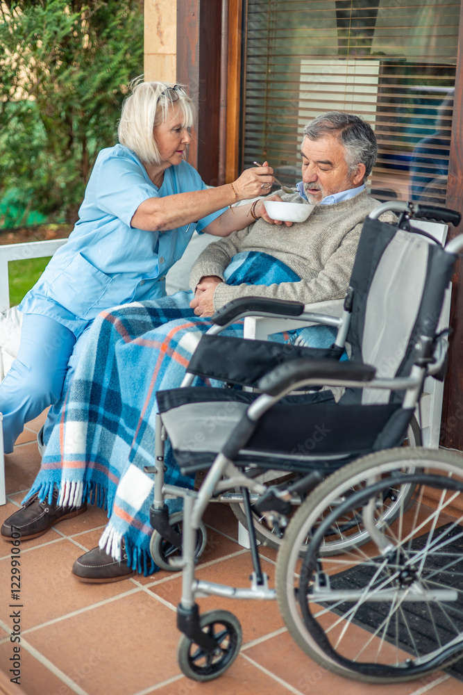 vertical Nurse assisting elderly man in wheelchair eating a healthy meal vertical Nurse assisting elderly man in wheelchair eating a healthy meal