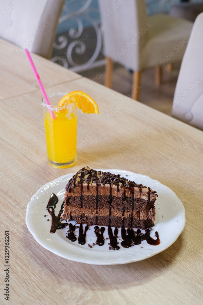 Chocolate cake slice with orange juice on a table Chocolate cake slice with orange juice on a table