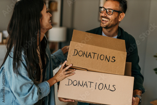 Spreading kindness. Man and woman carrying a donation box filled with clothing items