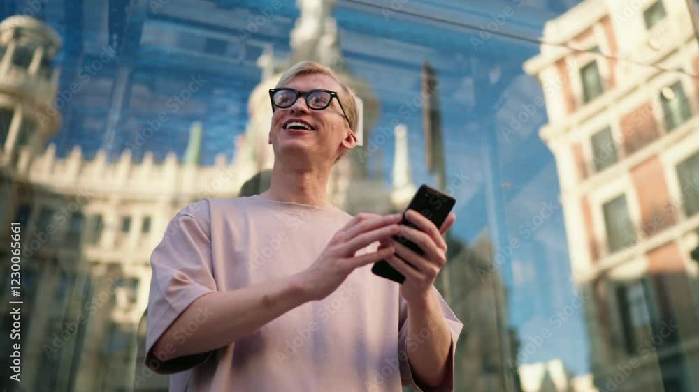 Cheerful man enjoys scrolling through social media on smartphone app, smiling as he views friends' photos. Historic urban backdrop, young male technology user checking online banking and sending money Cheerful man enjoys scrolling through social media on smartphone app, smiling as he views friends' photos. Historic urban backdrop, young male technology user checking online banking and sending money